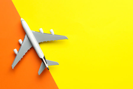 Plane model flying on color background, top view. Space for text