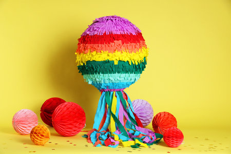 Colorful pinata and party decor on yellow backgroundの写真素材