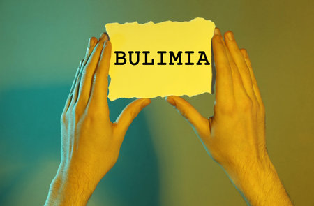 Man holding sheet of paper on color background, closeup
