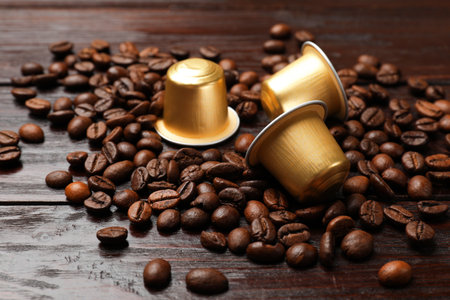 Coffee capsules and beans on wooden table, closeupの写真素材