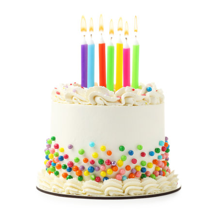 Delicious cake with colorful sprinkles and burning candles isolated on whiteの写真素材