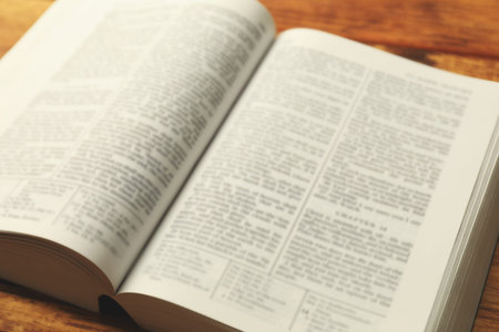 Open Holy Bible in English language on table, closeup