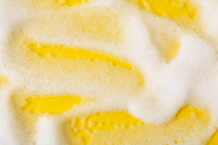 Sample of fluffy foam on orange background, top viewの写真素材