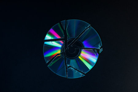 Broken compact disc on black background, top viewの写真素材