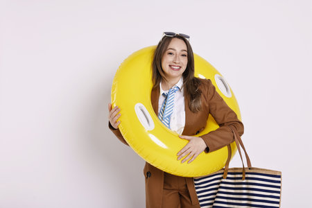 Businesswoman with inflatable ring, bag and sunglasses on white backgroundの写真素材
