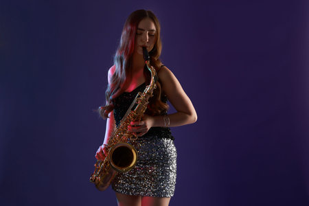 Professional musician playing saxophone on color backgroundの写真素材