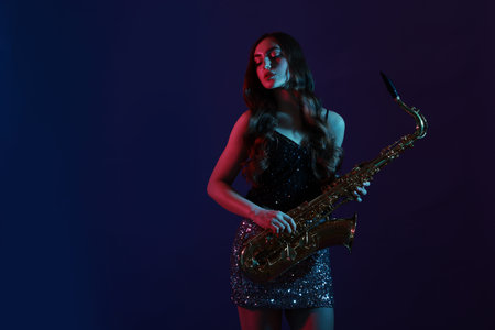 Professional musician with saxophone on color background. Space for textの写真素材