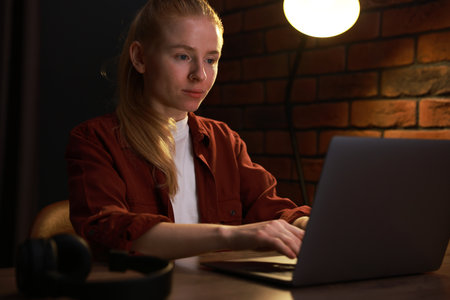 Woman working with laptop at table in officeの写真素材