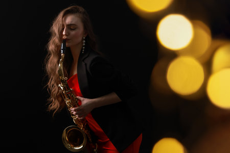 Professional musician playing saxophone on black background with blurred lights. Bokeh effectの写真素材