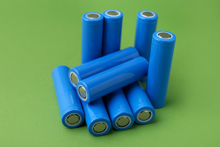 Many AA cell batteries on green background, closeupの写真素材
