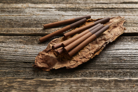 Dried tobacco leaf and cigarettes on wooden table, closeupの写真素材