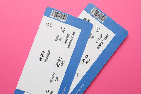 Travel agency. Flight tickets on pink background, top view