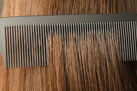 Brushing hair with plastic comb, closeup view