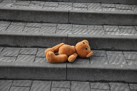 Brown teddy bear on stairs outdoorsの写真素材