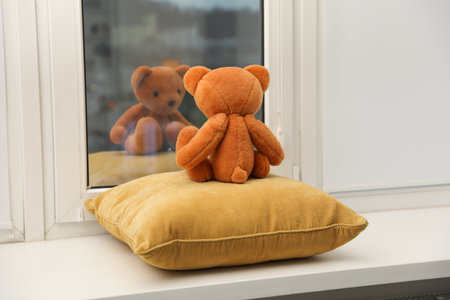 Teddy bear on window sill at home, back viewの写真素材