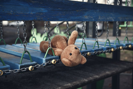 Lost brown teddy bear on playground outdoorsの写真素材