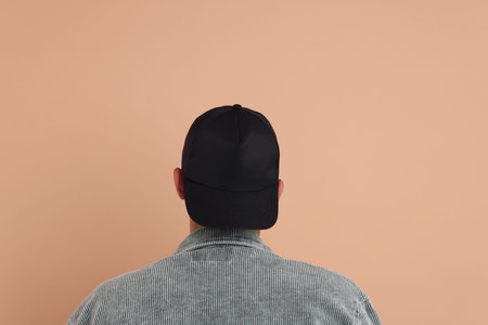 Man in stylish baseball cap on beige background, back view. Mockup for designの写真素材