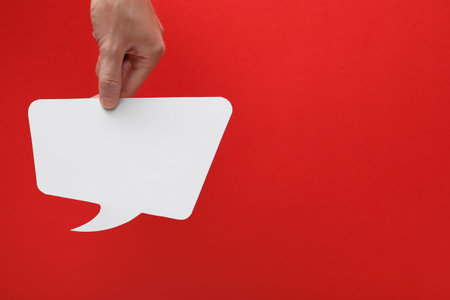 Woman holding blank speech bubble on red background, closeup. Space for text