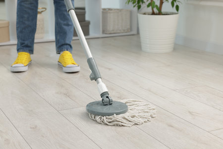 Woman floor cleaning with string mop indoors, closeup
