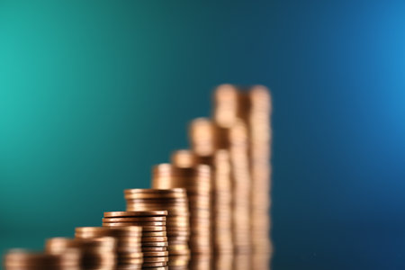 Stacks of coins on color mirror surface, closeupの写真素材