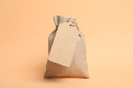 One burlap bag with tag on beige backgroundの写真素材