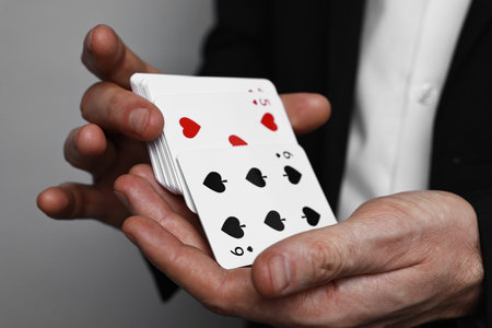 Illusionist shuffling playing cards on gray background, closeupの写真素材