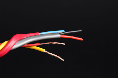 Many stripped electrical wires on black background, closeup