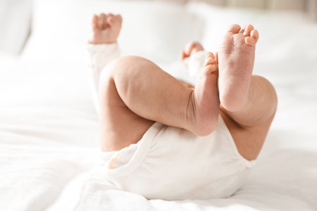 Little baby lying on bed indoors, closeupの写真素材