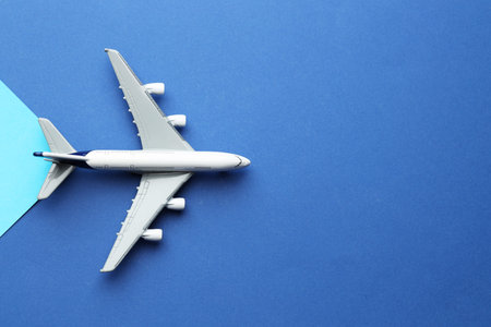 Plane model flying on color background, top view. Space for text