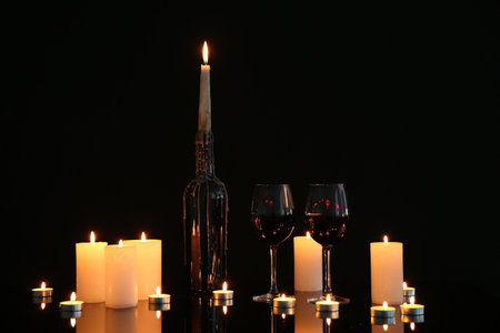 Many burning candles on mirror surface against black backgroundの写真素材