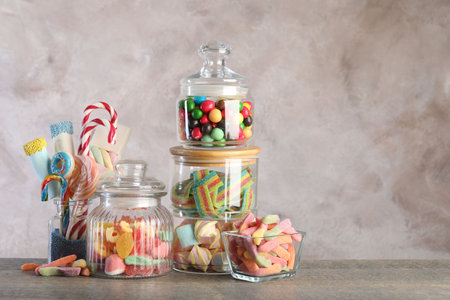 Candy bar. Many different sweets on wooden table against grey background. Space for textの写真素材