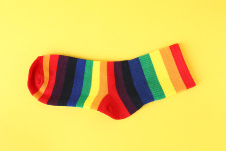 One sock in LGBT colors on yellow background, top viewの写真素材