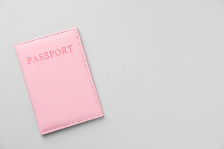 Passport in bright cover on grey background, top view. Space for textの写真素材