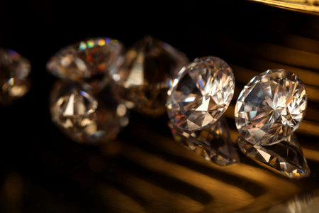 Beautiful shiny gemstones on golden tray in dark, closeup