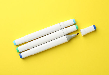 Double sided markers on yellow background, flat layの写真素材