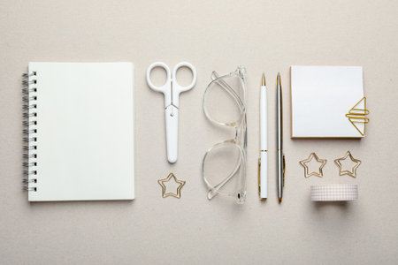 Paper clips, other stationery and glasses on light gray background, flat layの写真素材