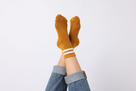 Woman wearing orange socks on white background, closeup