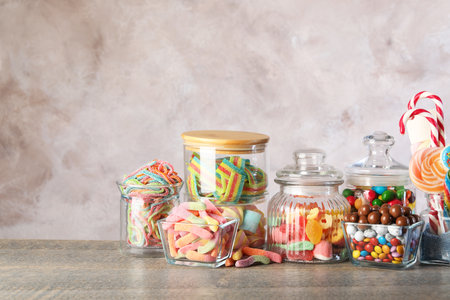 Candy bar. Many different sweets on wooden table against grey background. Space for textの写真素材