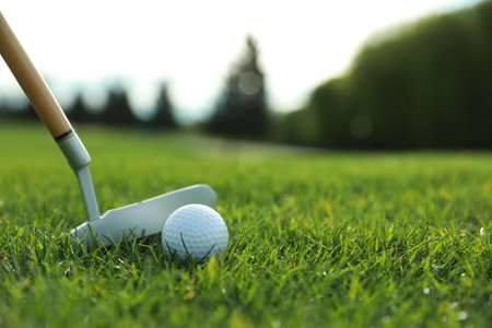 Hitting golf ball with club on green course, closeup. Space for textの写真素材