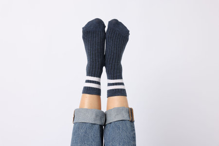 Woman wearing blue socks on white background, closeup
