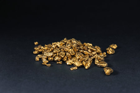 Shiny gold nuggets on black table, closeupの写真素材