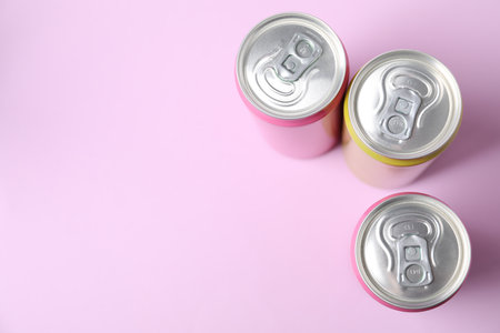 Three tin cans on light pink background, top view. Space for textの写真素材