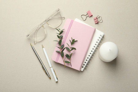 Binder clips, other stationery, glasses and decor on light gray background, flat lay