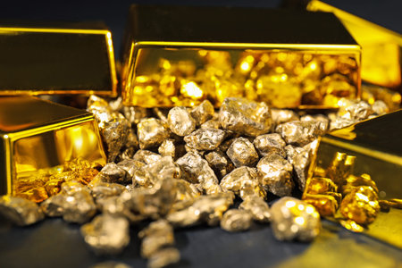 Gold nuggets and bars on black table, closeup
