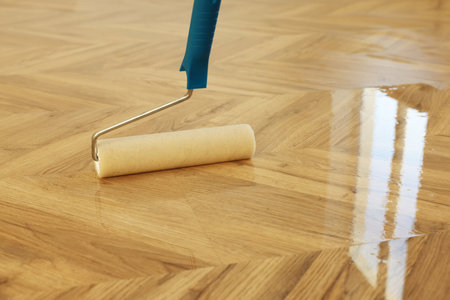 Polishing parquet with roller and varnish indoors, closeup. Space for textの写真素材