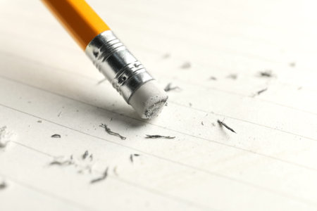 Using pencil with eraser on white sheet of paper, closeup