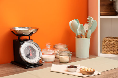 Kitchen scale, products and cooking utensils on wooden tableの写真素材