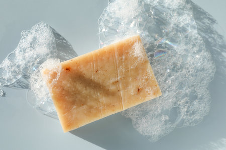 Soap bar with foam on grayish blue background, top viewの写真素材