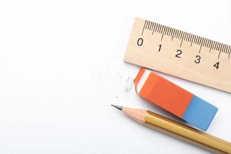 Eraser, ruler and pencil on white background, flat lay. Space for textの写真素材