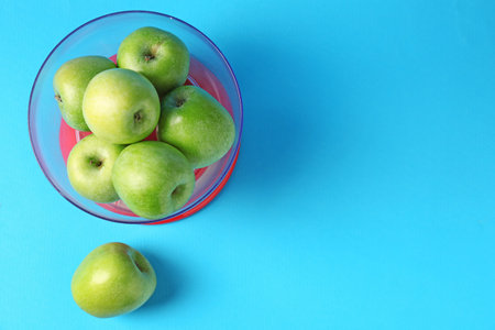 Kitchen scale with apples on light blue background, top view. Space for textの写真素材